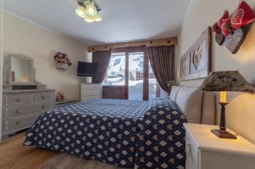 - une chambre avec un lit, une commode et une télévision dans l'établissement Bilocale sulle piste con wifi - AS6, à Breuil-Cervinia
