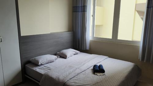 a bedroom with a bed with a hat on it at SleepRest @ NTC in Nagoya