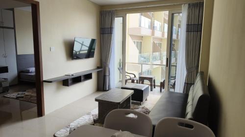 a living room with a couch and a television at SleepRest @ NTC in Nagoya