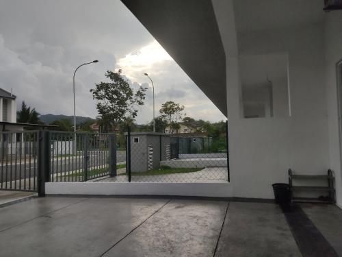 a view through an open door of a building with a fence at Hulu Yam Musliim Homestay in Batang Kali