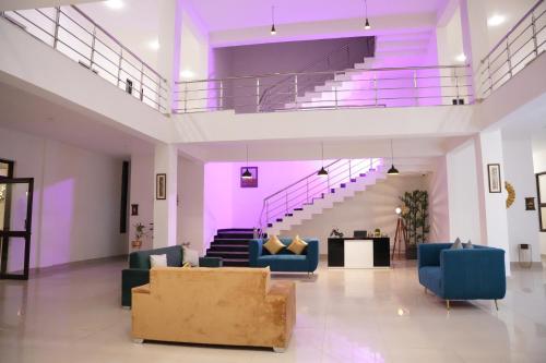 a living room with blue couches and a staircase at Pine Hideout in Kathua