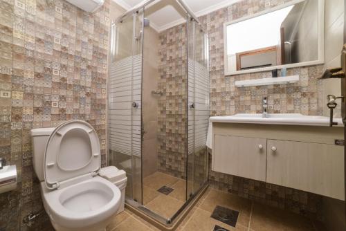 a bathroom with a toilet and a shower and a sink at Batroun boutique suites in Batroûn