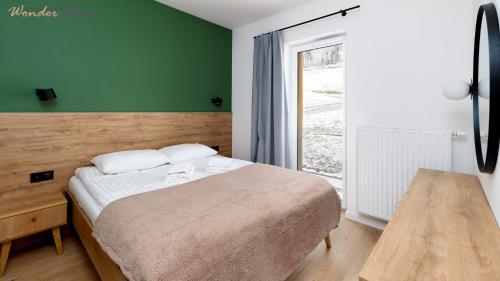 a small bedroom with a bed and a window at Wonder Home - Domki Hillside tuż przy stoku narciarskim - na terenie kompleksu plac zabaw i zewnętrzna siłownia, sklep, parking in Karpacz