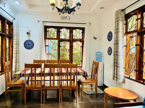 a dining room with a table and chairs and a window at Sophie Homestay in Moshi