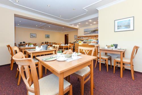 una sala da pranzo con tavoli e sedie in legno di Pension Nordkap a Bensersiel