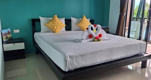 a large white bed with a stuffed animal on it at The Aireen Hotel in Ao Nang Beach