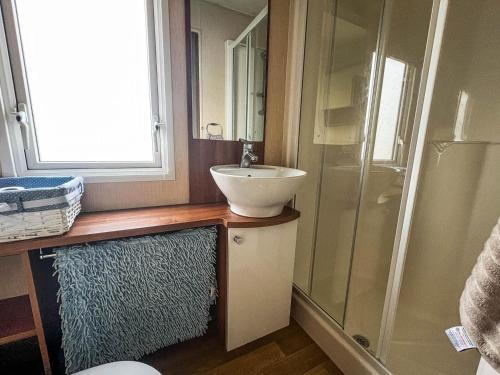 a bathroom with a sink and a shower at Lovely 6 Berth Caravan In Seaside Village Of Scratby, Norfolk Ref 19124s in Scratby