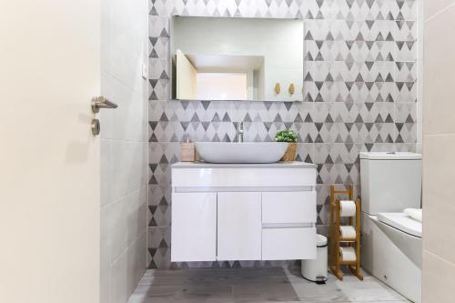 y baño con lavabo blanco y espejo. en BENFICA APARTMENTS II by HOMING en Lisboa