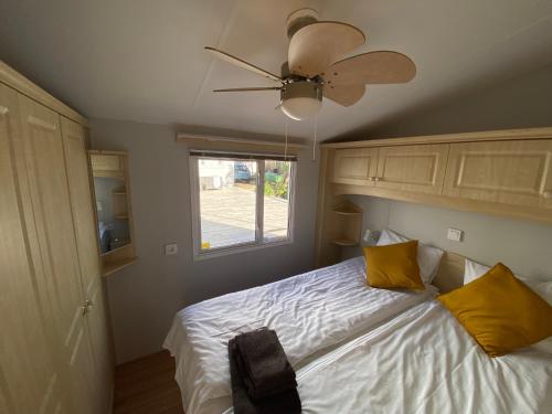 a bedroom with a bed with yellow pillows and a ceiling fan at La Mare Resort in Gothenburg