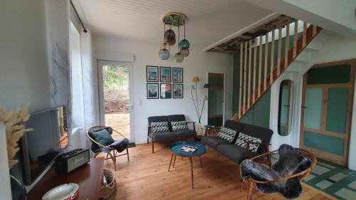 salon z kanapą i krzesłami w obiekcie L'Orée Du Bois w mieście Huelgoat