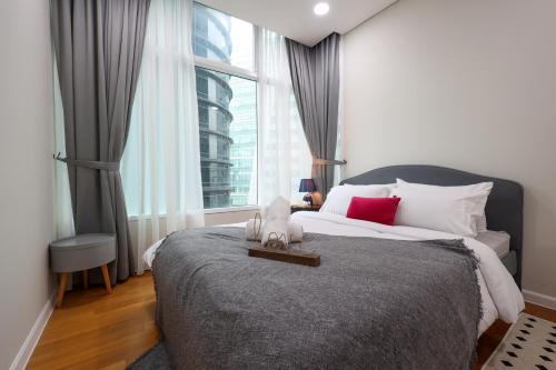 a bedroom with a bed with a teddy bear on it at Sky Suites KLCC By Calm Sojourn in Kuala Lumpur