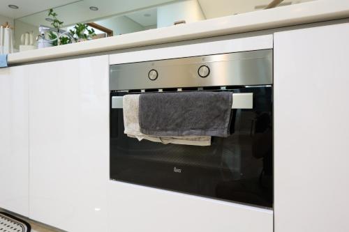 a kitchen with an oven with a towel hanging from it at Sky Suites KLCC By Calm Sojourn in Kuala Lumpur