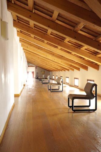 a large room with chairs and wooden ceilings at Campus San Francesco in Conegliano