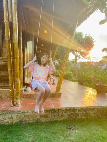a young girl sitting on a swing at ByVe Garden in Hanoi