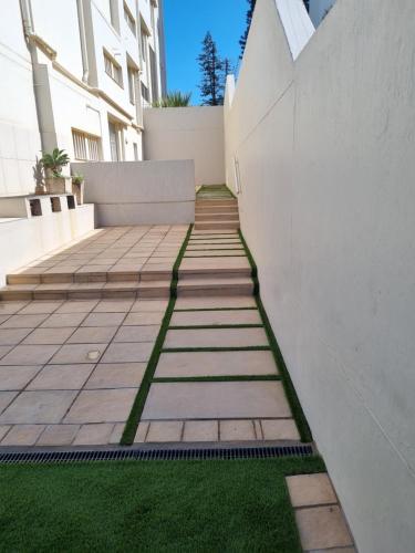 a walkway with green grass next to a building at 602 MARBELLA UMHLANGA DURBAN in Durban