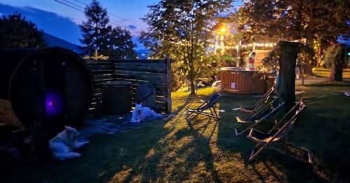 a group of chairs sitting in a yard at night at Agroturystyka Zagroda Miłkowskie in Słopnice