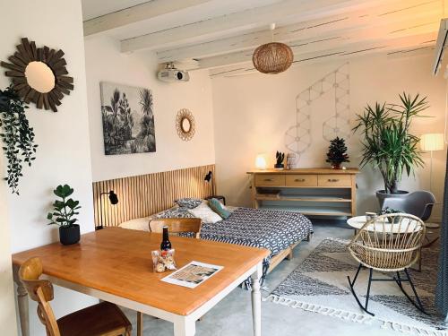 a living room with a table and a bed at Gîte Mozart - Marché de Noël in Colmar