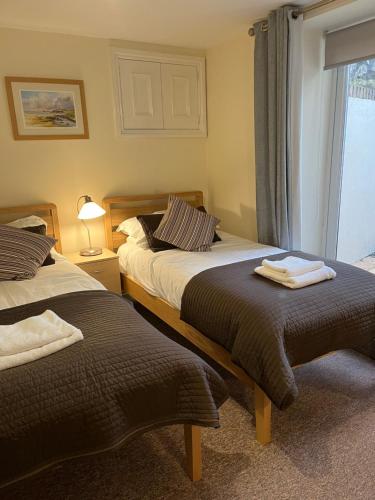 a bedroom with two beds and a window at Roker Seafront Apartments in Sunderland