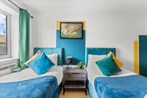 dwa łóżka w pokoju niebiesko-białym w obiekcie Enchanting Bristol Abode -Sleeps 6 with Balcony! w Bristolu