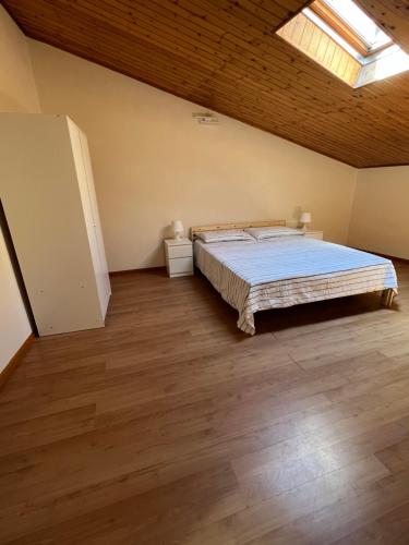 a bedroom with a large bed and a wooden ceiling at La mansarda di melo in Catania