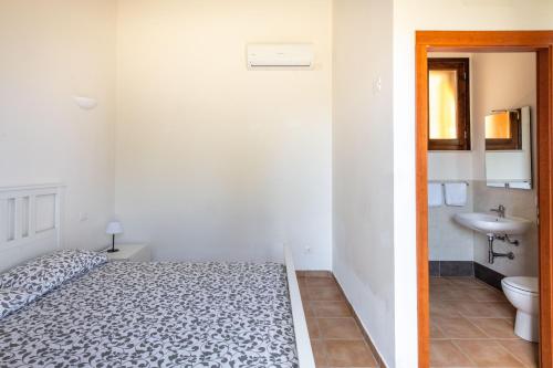 - une chambre avec un lit et une salle de bains pourvue d'un lavabo dans l'établissement Le Terrazze di Cefalù by Wonderful Italy, à Cefalù