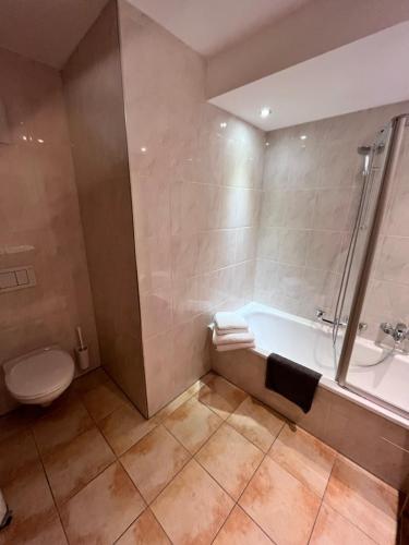 a bathroom with a tub and a toilet and a sink at Landhaus Alpenland in Zug