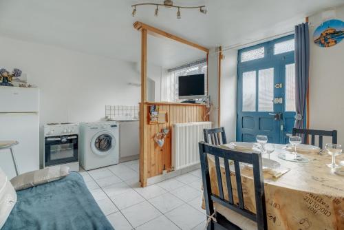 une salle à manger avec une table et une cuisine avec un lave-linge dans l'établissement Maison proche Mont St Michel, à Pontorson