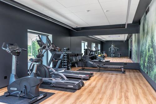 a gym with several treadmills and exercise bikes in a room at Väo Keskus Modern Guest Apartments in Tallinn