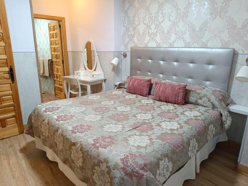 um quarto com uma cama grande e um espelho em The Vanilla Suite em Chinchón