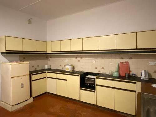 a kitchen with white cabinets and a refrigerator at Villa 95 in Dickwella
