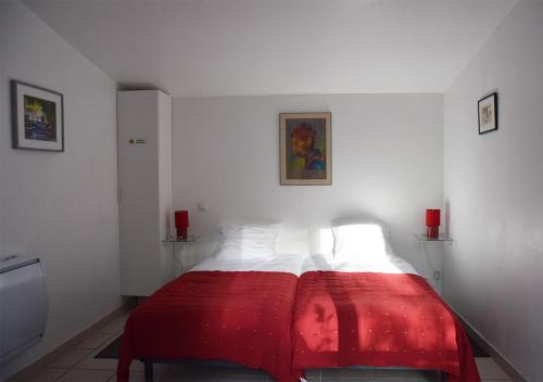 a bedroom with a red blanket on a bed at La Maison Des Invites in Pernes-les-Fontaines