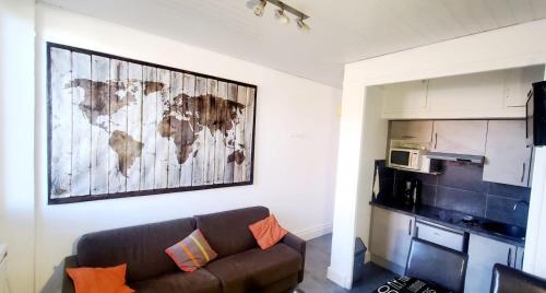 uma sala de estar com um sofá e um mapa na parede em Le Sof Paradis 2 T2 sur la plage des Lecques em Saint-Cyr-sur-Mer