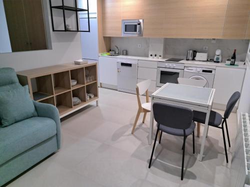 una cucina con tavolo, sedie e divano di Apartamentos Sudestada a Logroño
