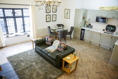 a living room with a couch and a table at The Penthouse at Mercers Croft in Stratford-upon-Avon