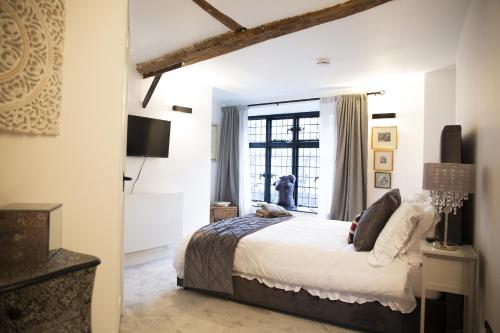 a bedroom with a bed and a window at The Penthouse at Mercers Croft in Stratford-upon-Avon