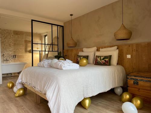 a bedroom with a bed with gold balloons on it at Madame Imagine, Lodges & SPA Epinal in Épinal