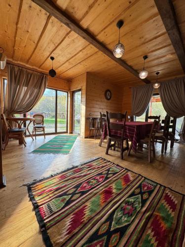 uma sala de estar com uma mesa e um tapete em Guest House Pid Dubom Карпати Під Дубом em Skole