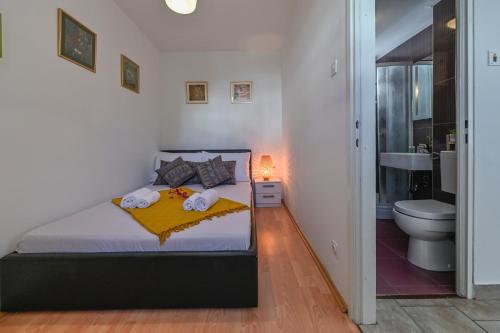 um quarto com uma cama e uma casa de banho com um WC em Apartment Adela II em Novalja