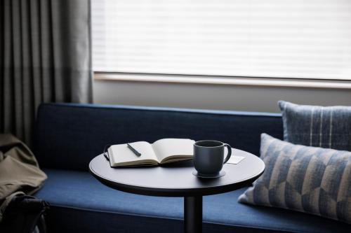 的住宿－Fairfield by Marriott Kyoto Kyotamba，咖啡桌,书,沙发上一杯