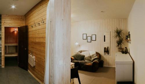 a living room with a couch and a wooden wall at Sauna apartment / Pirts apartamenti in Talsi