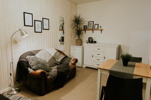 a living room with a couch and a table at Sauna apartment / Pirts apartamenti in Talsi