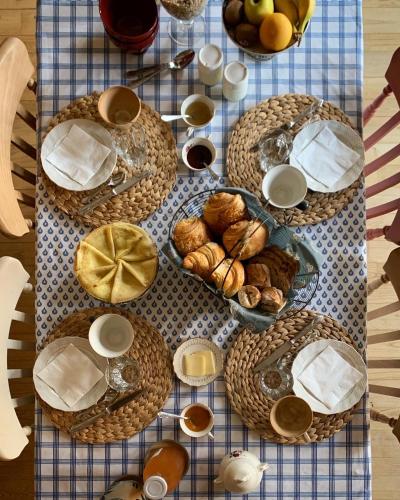 une table garnie de assiettes de pain et de tasses de café dans l'établissement Agritourisme Abaé, à Sougéal