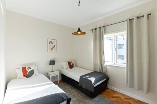 1 dormitorio con 2 camas y ventana en Ceuta Apartment, en Oporto