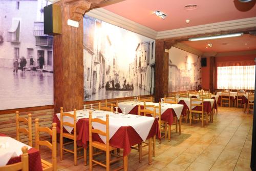 a restaurant with tables and chairs and a painting on the wall at Hostal Venecia in Azagra