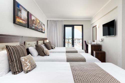 Postel nebo postele na pokoji v ubytování Livadhiotis City Hotel