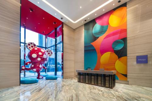a lobby of a building with a large painting of a red molecule at Maqo Changsha in Changsha