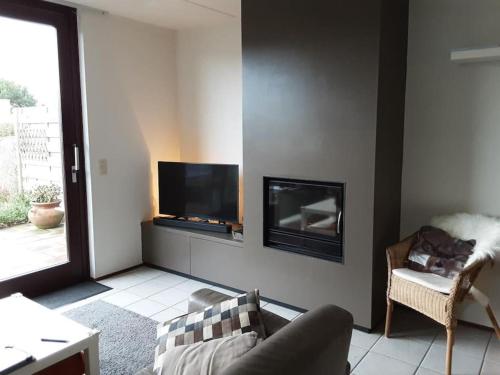 uma sala de estar com um sofá e uma televisão de ecrã plano em Heggerank 5B* em Nieuwvliet