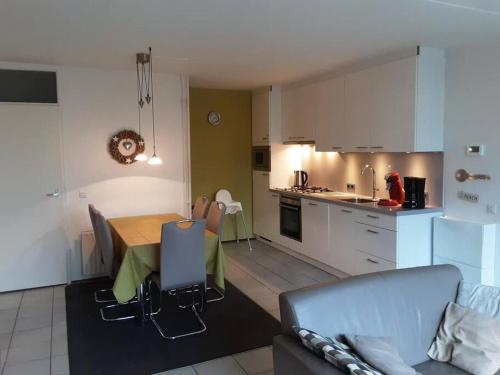 een keuken en een woonkamer met een tafel en een bank bij Heggerank 5B* in Nieuwvliet