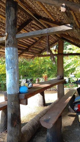 a wooden picnic table under a wooden roof at Elena Garden Resort and Restaurant in Trincomalee