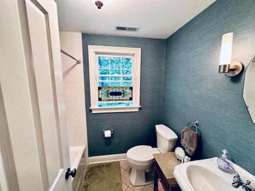 La salle de bains est pourvue de toilettes, d'un lavabo et d'une fenêtre. dans l'établissement Upmarket Country Retreat, Washington, Connecticut, à Washington